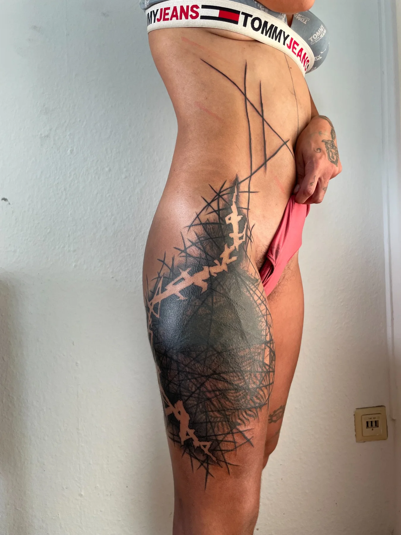 Experimental blackwork tattoo on hip and thigh